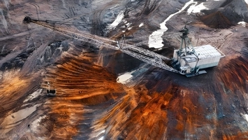 Large-scale mining excavator operating in an open-pit mineral extraction site