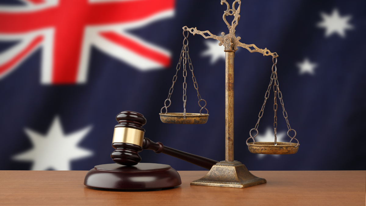 Scales and gavel in front of Australian flag symbolising national regulatory action.