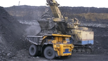 Large mining excavator loading rock into a haul truck at an open-cut mine